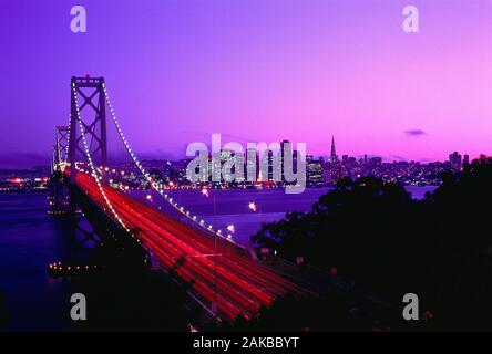 Lange Belichtung geschossen von Golden Gate Bridge mit leichten Wanderwegen und beleuchtete bei Sonnenuntergang, San Francisco, Kalifornien, USA Stockfoto