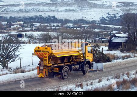 Schneepflug Schneeräumen und die Verbreitung von Splitt auf der Straße in der Nähe von Brecon Mountain Brynamman in den Brecon Beacons National Park. Stockfoto