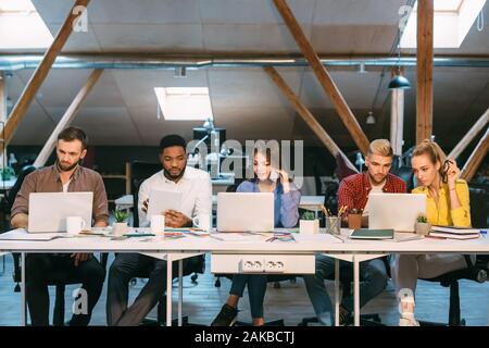 Team von Programmierern in Software entwickelnde Unternehmen arbeitet, mit Laptops, freier Speicherplatz Stockfoto