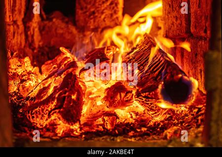 Brennholz brennt in den Herd. Das Konzept der Home Wärme und Komfort. Urlaub zu Hause. Stockfoto