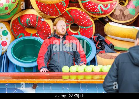 London, Großbritannien - 25. November 2019 - Carnival Game Operator bittet Kunden auf der Weihnachtsmesse Winter Wonderland Stockfoto