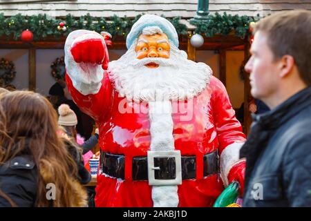 London, Großbritannien - 25. November 2019 - Statue des Weihnachtsmannes auf der Weihnachtsmesse Winter Wonderland mit vorbeifahrenden Touristen im Vordergrund Stockfoto