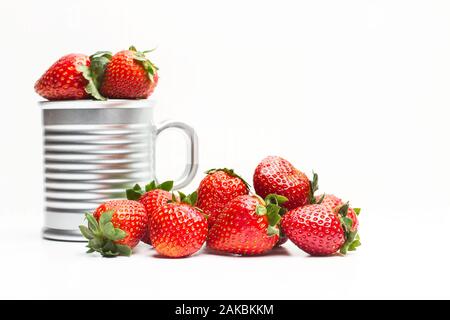 Rote, köstliche Erdbeeren in einem Becher und auf weißem Hintergrund Stockfoto