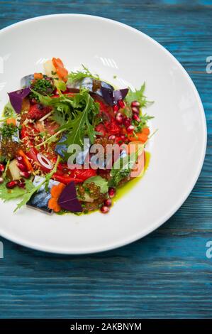 Escabeche Fischgericht mit Kaviar: Makrele in Marinade mit Gemüse, auf einem Schild auf dem Holz- blauen Hintergrund. Stockfoto