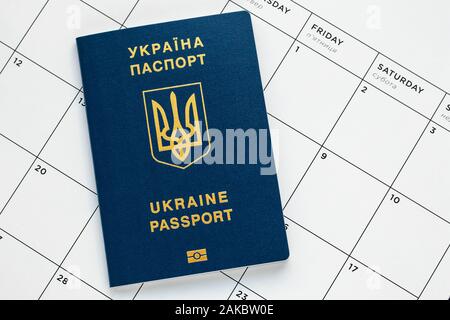 Ukrainische biometrischen Pass auf der weißen Seite des Kalenders. Planung Ferienhäuser Konzept. Internationalen blauen Reisepass Stockfoto