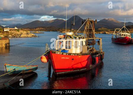Irland, County Galway, Connemara, Ballynakill, Holzboote und Fischerboote im Hafen, Tully Berge und die Twelve Bens Berge im Hintergrund Stockfoto