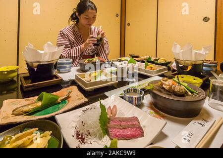 Japan, Kyushu Island, Kumamoto Region, Kurokawa, Onsen Ryokan Okunoyu, traditionelle Luxury Inn in einem Kurort gelegen, junge asiatische Frau im Kimono genießen Sie traditionelle Mahlzeit im Zimmer serviert Stockfoto