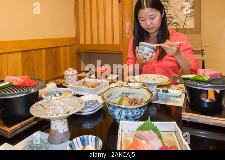 Japan, Kyushu Island, Kumamoto Region, Kurokawa, Onsen Ryokan Okunoyu, traditionelle Luxury Inn in einem Kurort gelegen, jungen asiatischen junge Frau genießen Sie traditionelle Mahlzeit im Zimmer serviert Stockfoto