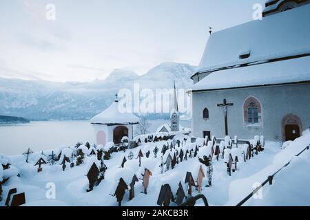 Berühmte Hallstatt Stadt am See mit Kirchturm und Friedhof auf einer schönen kalten Morgen im Winter, Salzkammergut, Österreich Stockfoto