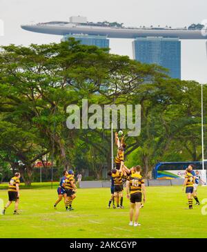 Singapur - Jan 16, 2017: Zwei laienhaften Rugby Team play Rugby in Singapur. Marina Bay Sands Hotel auf dem Hintergrund Stockfoto