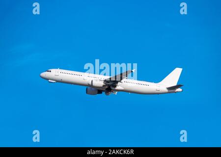 Passagierflugzeug setzt sich in den blauen Himmel Seitenansicht Stockfoto