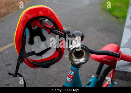 Ein Kinderrad mit einem Radhelm, der an den Griffstangen hängt Stockfoto