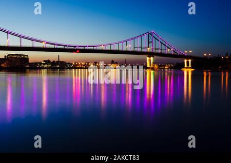 Nacht Landschaft. Der Stadt Kiew, Ukraine, Europa. Fußgängerbrücke über den Fluss Dnepr. Schöne Beleuchtung und Spiegelung im Wasser Stockfoto