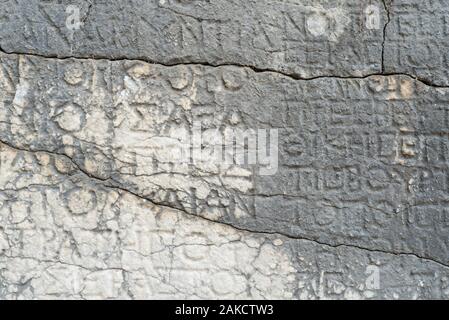 Antike Inschrift auf einer Steinmauer. Historische Wahrzeichen in der alten, verfallenen Stadt Faselis, Türkei Stockfoto
