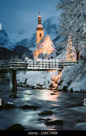 Schöne Dämmerung Blick auf Sankt Sebastian Wallfahrtskirche mit geschmückten Weihnachtsbaum während der Blauen Stunde leuchtet in der Dämmerung im Winter, Ramsau, Nat Stockfoto