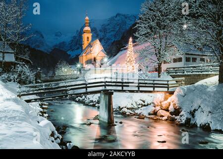 Schöne Dämmerung Blick auf Sankt Sebastian Wallfahrtskirche mit geschmückten Weihnachtsbaum während der Blauen Stunde leuchtet in der Dämmerung im Winter, Ramsau, Nat Stockfoto