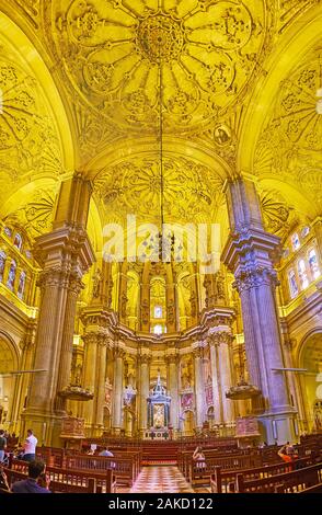 MALAGA, SPANIEN - 26. SEPTEMBER 2019: Der Altar der Kathedrale, von geschnitzten Säulen umgeben, gemalte Symbole und Buntglasfenster, am 2. September Stockfoto