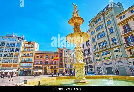 MALAGA, SPANIEN - 26. SEPTEMBER 2019: Der Blick auf die Gebäude der Plaza de la Constitucion (Platz der Verfassung) durch die weißen Marmor Genua Brunnen, o Stockfoto