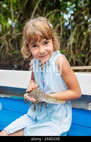 Das Kind hält ein kleines Krokodil in seinen Händen. Selektive konzentrieren. Stockfoto