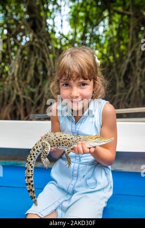 Das Kind hält ein kleines Krokodil in seinen Händen. Selektive konzentrieren. Stockfoto