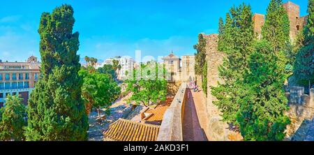 MALAGA, SPANIEN - 26. SEPTEMBER 2019: Panoramablick auf die Festung Alcazaba mit mittelalterlichen Türmen, Gasse entlang der Stadtmauer und das Tor von Spalten (Puerta Stockfoto