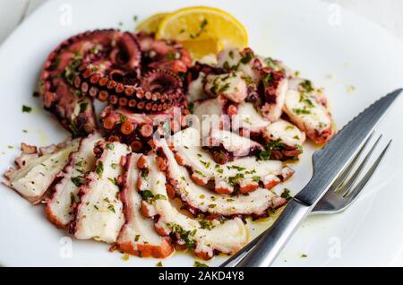 Meeresfrüchte Vorspeise. Tintenfisch Carpaccio auf weiße Platte. Mediterrane Delikatesse. Selektiver Fokus Stockfoto
