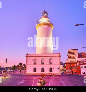 Den Leuchtturm von Malaga Hafen (La Farola) mit bunten Abend Himmel im Hintergrund, Spanien Stockfoto