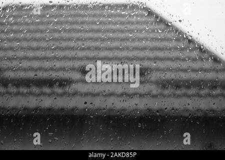 Im Fenster Regentropfen, Wassertropfen auf Glas, Fliesen- Dach im Freien Stockfoto