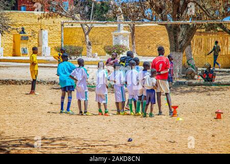 Insel Goree, Senegal - 22. April 2019: Unbekannter Jungs spielen Fußball auf dem Sand in der Stadt in Afrika. Die Jungs sind ein weißes Football Jersey. Stockfoto