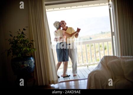 Senior Paar tanzen zusammen auf dem Balkon. Stockfoto