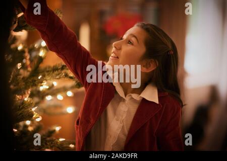 Ein Mädchen schmücken einen Weihnachtsbaum. Stockfoto