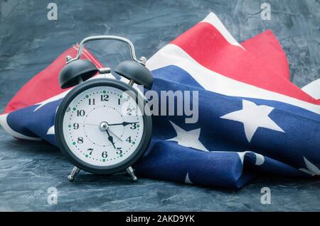 Nationalflagge von Amerika und schwarzen Wecker auf dunklem Hintergrund Stockfoto