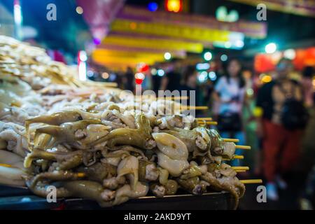 Bangkok/Thailand-December 2019: Roh ungekocht Tintenfisch auf Holzspieße in einem Haufen Warten an einer Straße gelegene Restaurant in Chinatown gekocht zu werden Stockfoto
