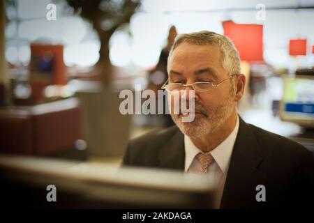 Im mittleren Alter Geschäftsmann an seinem Computer zu arbeiten. Stockfoto