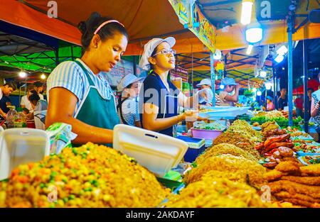 PATONG BEACH, THAILAND - 1. Mai 2019: Die Köche der Straße essen in Banzaan Fresh Market Stall machen das Gemüse Salate mit geräuchertem Fleisch, Deep Fried Chicken Stockfoto