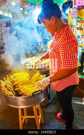 PATONG BEACH, THAILAND - Mai 1, 2019: Die Straße essen Verkäufer macht gekochten Mais in Banzaan frische Markt, am 1. Mai in Patong Stockfoto