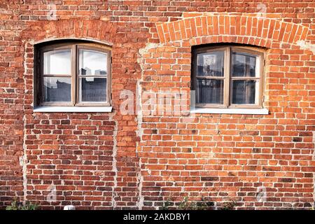 Old Red Brick Wall mit Windows. Stockfoto