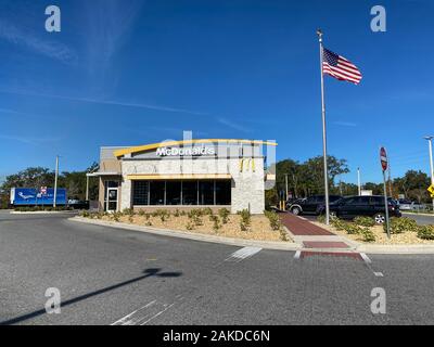 Orlando, FL/USA = 1/7/20: Das Äußere eines McDonalds Fast Food Restaurant mit einer US-Flagge an einem hellen, sonnigen Tag. Stockfoto