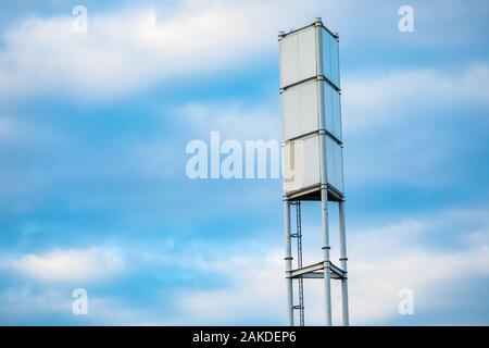 Eine niedrige Winkel Blick auf ein Funksignal Turm, hohen Stahlrahmen mit Aufstiegsleiter. Signal Rundfunk Infrastruktur gegen einen blauen Himmel mit Kopie Raum Stockfoto