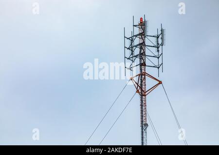 Ein niedriger Betrachtungswinkel und einer Zelle website Turm, mit sichtbaren coaxial Transmission Line up ein Kabel Stahl Gittermast mit Kopie Raum waren nach rechts Stockfoto