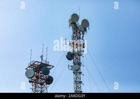 Telekommunikation und mobile Infrastruktur mit zwei mobilfunkmasten, Seite an Seite, Gehäuse Antennen und Remote Radio Head, RRH, für größere Reichweite Stockfoto