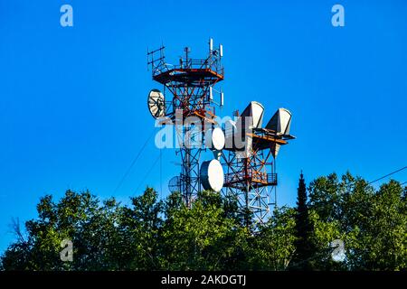 Ein niedriger Betrachtungswinkel und einer Zelle website Turm auf einem Kabel Stahlgitter pylon, Mikrowelle Antenne für 3G, 4G, 5G-Datenübertragung und Signal boost Waren Stockfoto