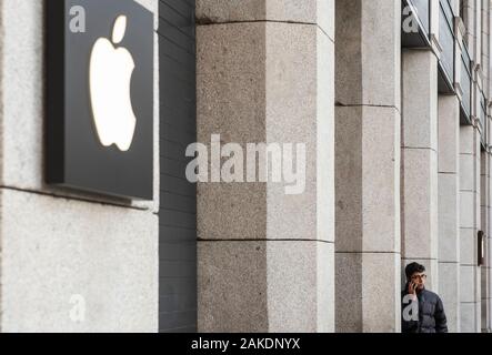Der Mensch nutzt sein Handy am Eingang der amerikanischen multinationalen Unternehmen Apple Store in Madrid, Spanien. Stockfoto