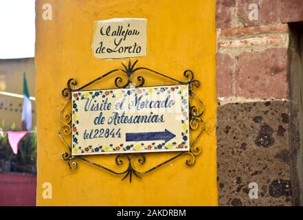 Keramik Straßenschild mit der Wegbeschreibung zum Mercado de Artesanias auf dem Callejon de Loreto, San Miguel de Allende, Mexiko; Stockfoto