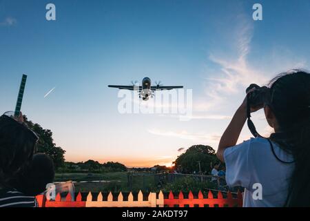 Planespotters Line Airplane Alley, Kameras bereit, da ein ATR 72 Turboprop eine Annäherung an den Flughafen von Taipeh Songshan macht Stockfoto