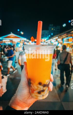 Die Hände der Touristen halten Taiwanesische Bubble Tea an Dongdamen Nachtmarkt, Hualien, Taiwan Stockfoto