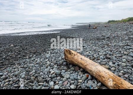 Starke Wellen brechen auf der felsigen Ufer des Dulan Beach, im südlichen Taiwan, nach einem Zyklon vorbei, große Stücke Treibholz Stockfoto