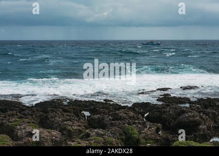 Ein kleines Fischerboot Segel in rauer See vor der südlichste Punkt in Taiwan Stockfoto