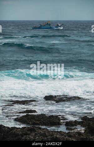 Ein kleines Fischerboot Segel in rauer See vor der südlichste Punkt in Taiwan Stockfoto