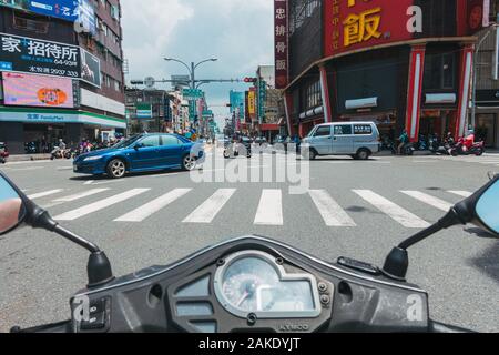 Blick von einem Motorroller während an einer Kreuzung in Tainan, Taiwan, an einem heißen Sommertag Stockfoto